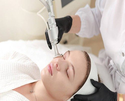 Dermatologist performing laser removal treatment on a patient's skin for seborrheic keratosis removal in a modern clinical setting